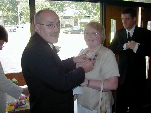 Phil helps Celia with her flower.
