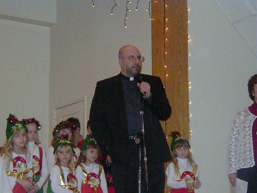 Father Ron announcing the arrival of St. Nicholas.